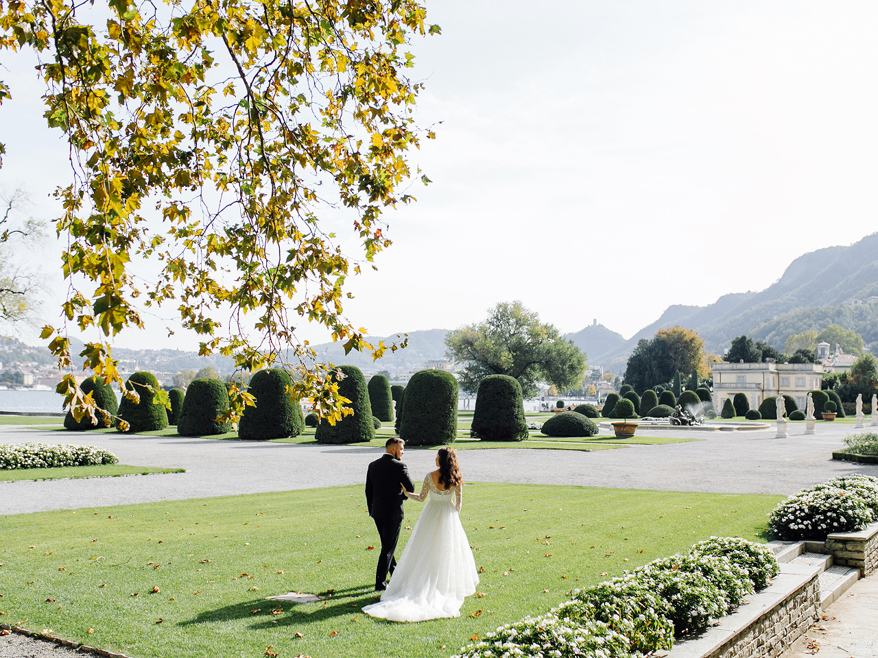 Bride and groom walking through a landscaped garden at a destination wedding venue