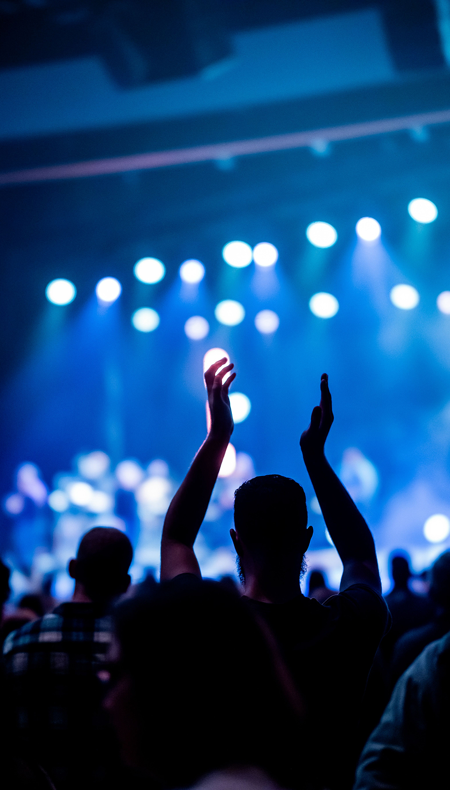 Audience enjoying a concert under blue stage lighting